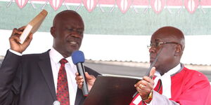 Siaya Governor Cornel Rasanga Amoth (left) takes the oath of office when he was sworn-in by Justice Aggrey Muchelule at Siaya Stadium in 2013