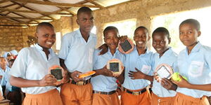 Students holding samples of the portable solar lights donated by Mwezi Foundation