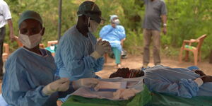 Surgeon Samson Lokele and Maurice Albony operate on a patient.