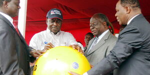 Former Minister for Information Samuel Poghisio (left) and former Permanent Secretary Dr. Bitange Ndemo (right) hold a huge buoy as President Kibaki (second right) looks on, and Prime Minister Raila Odinga (second left) at the Fort Jesus sea front on June, 12 2009. 
