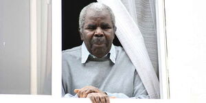 The late Billionaire Gerishon Kirima peeps outside his window in 2010.