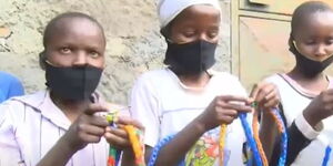 The special social group of children from Bahati, Nakuru, making skipping ropes from plastic bottle tops.