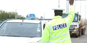 A Traffic police officer attached to Kisumu Central Police Station stops an oncoming vehicle during a crackdown along Nairobi Road on January 28, 2020. 
