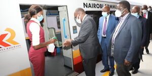 Transport CS James Macharia (second left) sanitises his hands while preparing to board a train on Monday, December 7, 2020.