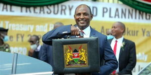 Former Treasury Cabinet Secretary Ukur Yatani poses for a photo with the famous budget briefcase outside parliament buildings on Thursday, April 7,2022.