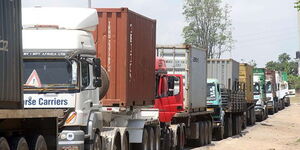 Trucks held up at a traffic snarl-up along a highway.