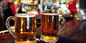 Two mugs of beer in a bar.