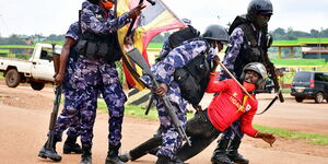 Ugandan riot police officers detain a supporter of presidential candidate Robert Kyagulanyi, also known as Bobi Wine