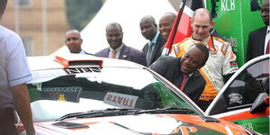 President Uhuru Kenyatta enters a rally car driven by Ian Dancun during the KCB Safari Rally flagging off ceremony at KICC Nairobi, on September 21, 2014.
