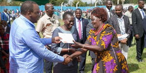 President Uhuru Kenyatta and CS Farida Karoney issuing title deeds to Coast residents