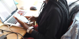 A file image of a woman using a phone.