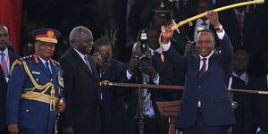 Former president Mwai Kibaki hands over the tools of power to President Uhuru Kenyatta in 2013.