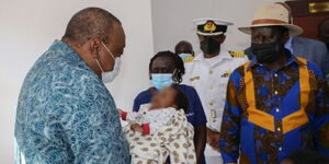 President Uhuru Kenyatta Carrying a two-month-old baby at the Kibera Level 3 Hospital on September 29,2021.