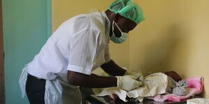 A clinical officer conducts circumcision on a 30-day old baby at the Homa Bay Referal Hospital in 2019.