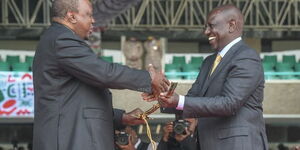 Former President Uhuru Kenyatta handing over the sword to President William Ruto at Kasarani Stadium on September 13, 2022