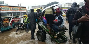 A man in Nairobi transporting people using a cart after the city flooded.