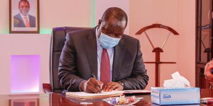 Interior CS Fred Matiang'i signs the visitor's book at PDU's new offices at Tourism Fund Building on September 23, 2020