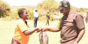 Janet Adhiambo gifting fish to Deputy President William Ruto in Migori on October 11, 2021.