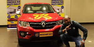 Zadock Sanawa posing for a photo with his newly won car on December 2, 2021.