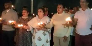 Deputy Chief Justice Philomena Mwilu (center) holds a lamp to perform a Hindi ritual for a spiritual leader during her trip to India. 