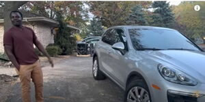 An image of Obadiah beside his Porsche Cayenne.