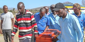 Pall bearers carry the casket bearing the bodies of the Nakuru quintuplets at the Nakuru South Cemetery on February 2, 2023. 
