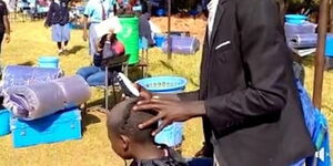 An image of a form one student being shaved at Kereri Girls High School