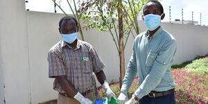 Vipingo Development General Manager Raphael Nyamai and Community liaison officer Mwalimu Swaleh pose with a hamper of donations in Vipingo area, Kilifi on Wednesday, April 22, 2020.