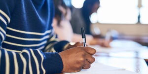 A file image of a student holding a pen