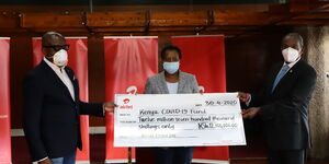 Airtel Africa PLC Vice President Corporate Affairs & CSR, Michael Okwiri (L) presents a cheque of Kshs.12.7 million to the Covid 19 Emergency Fund chairperson Ms. Jane Karuku (M) during a press briefing on Thursday, April 30.