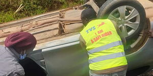 Witnesses attempt to pull a car that landed in a ditch in Eldoret on Sunday, May 17, 2020.