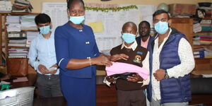 George Masinde (center) alongside representatives of Mombasa Cement Limited at St Joseph's Boys High School. 