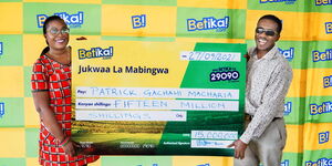 Patrick Macharia (right) receiving a cheque of Ksh15 million