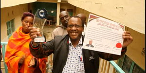 Kinangop landlord Michael Munene holds trophy and certificate from his tenants