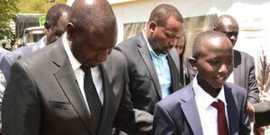 Deputy President William Ruto with Sergeant Kipyegon Kenei's son in Nakuru County on Saturday, March 7, 2020