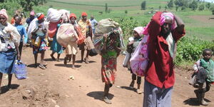 Women carrying their belongings flee from Marioshoni in Njoro, Nakuru County on July 31, 2020 following chaos that erupted in the area.