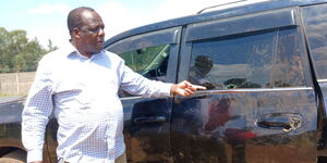 Former Kakamega Governor Wycliffe Oparanya analysing damage to his vehicle during the Wednesday, July 132 demonstrations.