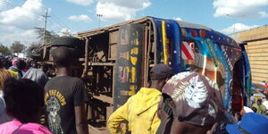 A crowd mills around the bus that overturned along Thika Road.