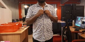 A man buttoning his shirt at an office setting.