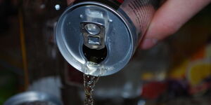 A man holding an energy drink can.