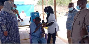 Amina Abdalla (left)  observing mental ill patient receiving covid jab. Photo: Mombasa Women Empowerment Network - Mental Rescue Center 