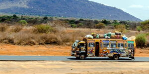 A long-distance bus travelling on a Kenyan Road.