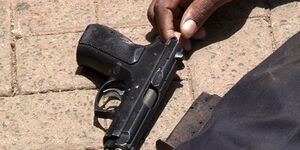A person lying next to a gun