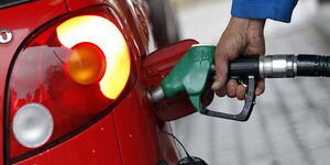 A person refuels his car at a petrol station.