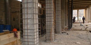 A photo of construction workers jacketing columns on a building 