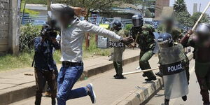 A photo of police officers going after a protester during a demonstration 