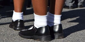 A schoolgirl dressed in black shoes and white socks.