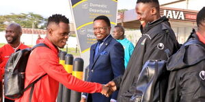 Sports Cabinet Secretary Ababu Namwamba with Harambe Stars players at Jomo Kenyatta International Airport on November 15, 2023