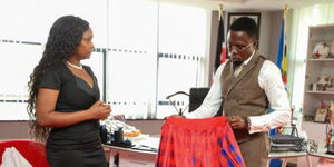Wanja Ngare display some of her artistic work with Sports Cabinet Secretary Ababu Namwamba on June 7, 2027.