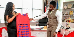 Wanja Ngare display some of her artistic work with Sports Cabinet Secretary Ababu Namwamba on June 7, 2027.